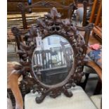 A 19th century oval Black Forest carved walnut wall mirror, width 54cm, height 66cm