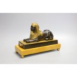 A parcel gilt bronze model of a sphinx on a Siena marble base - 22cm long
