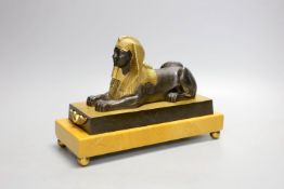 A parcel gilt bronze model of a sphinx on a Siena marble base - 22cm long