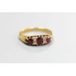 A late Victorian 18ct gold, three stone ruby and four stone diamond set half hoop ring, size M,