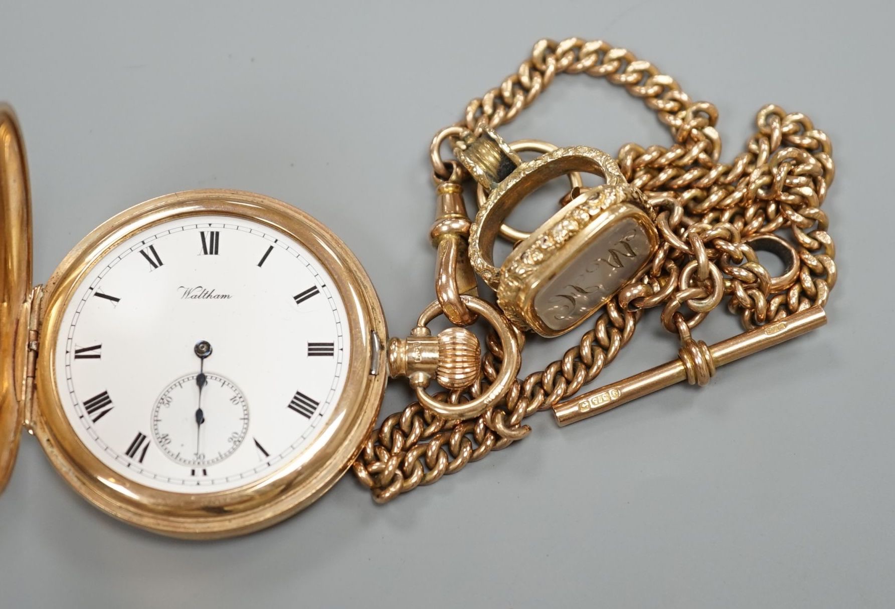 A 1920's 9ct gold Waltham keyless half hunter pocket watch, on a 9ct gold albert, hung with a