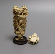 A Japanese ivory okimono of a monkey carrying a lotus leaf containing toads, on its back and an