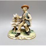 A Capodimonte figure of a tramp sat on a bench feeding doves 27cm