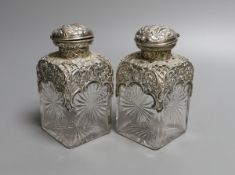 A pair of late Victorian repousse silver mounted cut glass scent bottles with stoppers, William