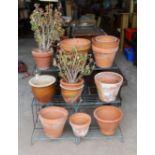 A painted wrought iron three tier pot stand together with a collection of 13 assorted terracotta and