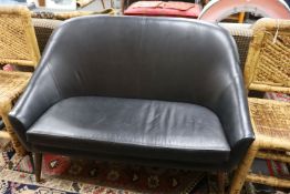 A mid century design black leather tub framed settee, length 136cm, depth 76cm, height 89cm