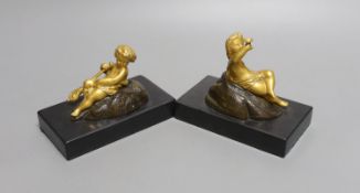 A pair of ormolu putto paperweights on black marble bases,13 cms wide.