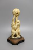 A Japanese ivory okimono of the three wise monkeys supporting a puzzle ball, early 20th century,