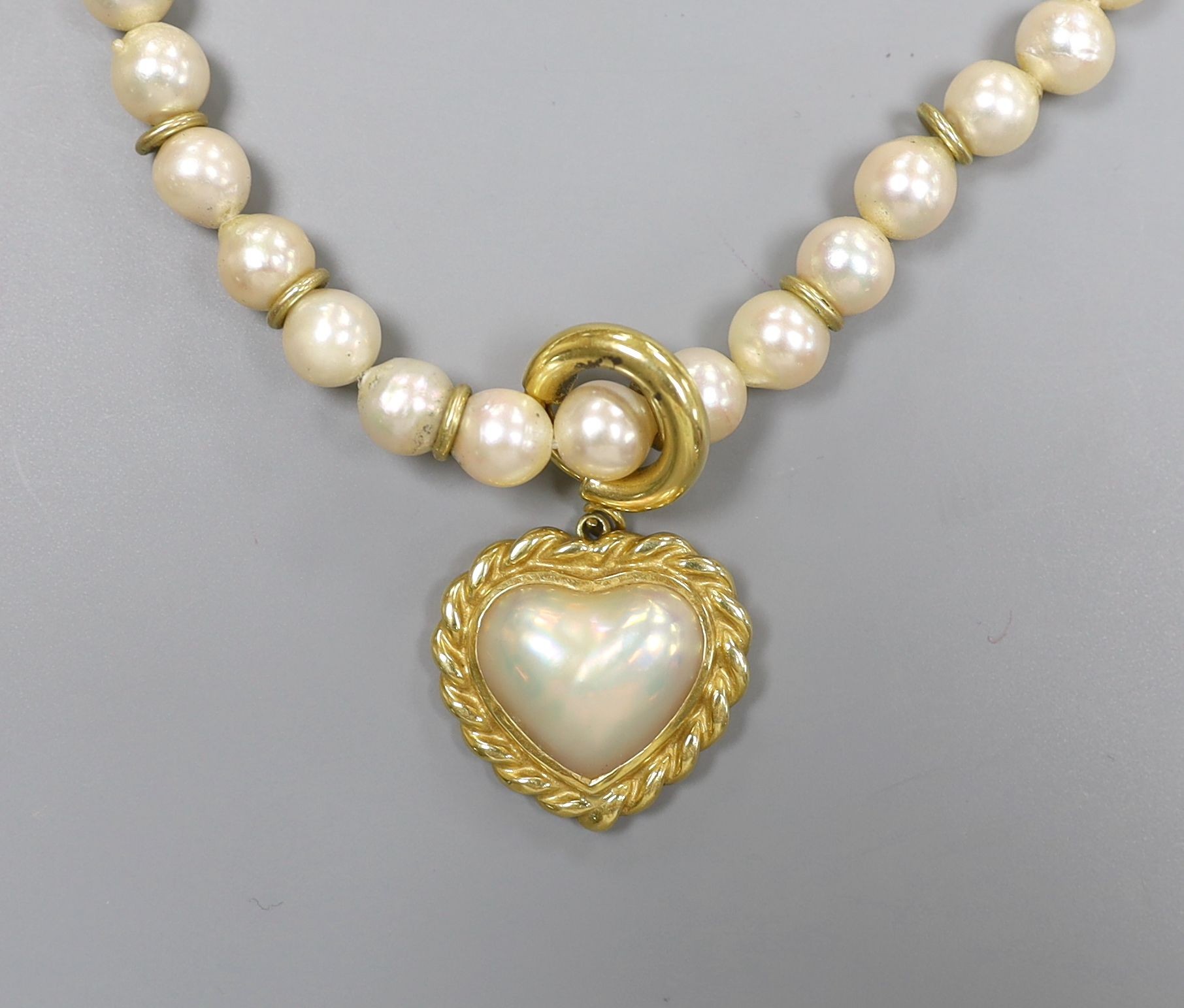 A 1960's single strand cultured pearl necklace, with an 18ct gold and mother of pearl set heart