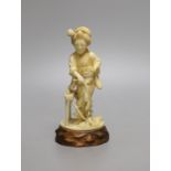 A Japanese Tokyo school carved ivory figure of a woman flailing wheat, Meiji period, wood stand -