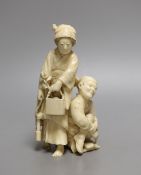 A Japanese ivory okimono of a crouching man and a woman holding a flower basket, Meiji period,