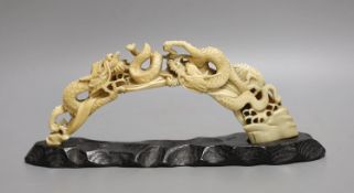 A Japanese boars tusk carving of two confronting dragons, Meiji period - 12cm high