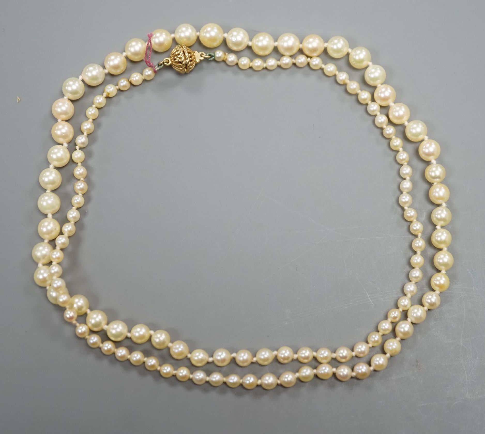 A singe strand graduated cultured pearl necklace with yellow metal clasp, 64cm, gross weight 20.3