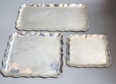 A graduated suite of three Austro-Hungarian white metal trays with wavy borders, largest 34.5cm,