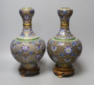 A pair of cloisonne vases, on carved wood plinths, 30cm