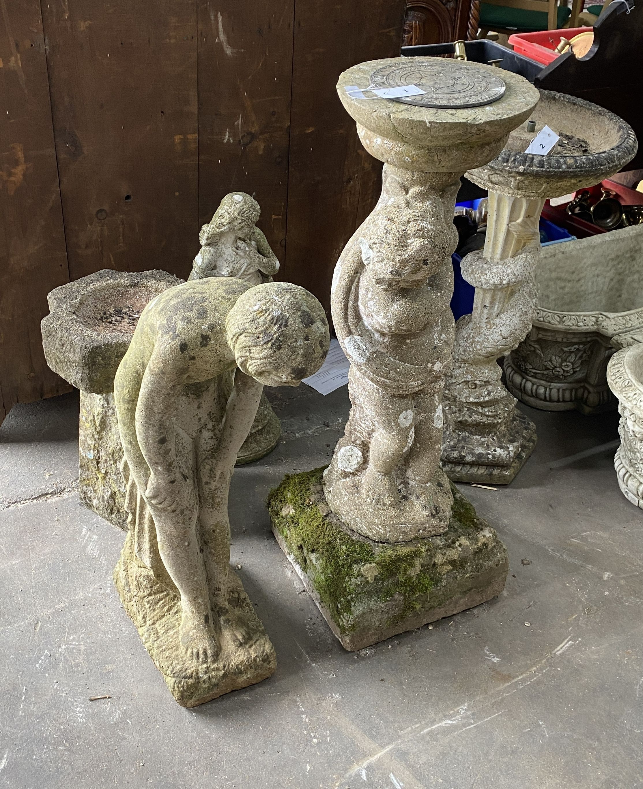 A reconstituted stone figural sundial, a female bather figure, bird bath and one other garden