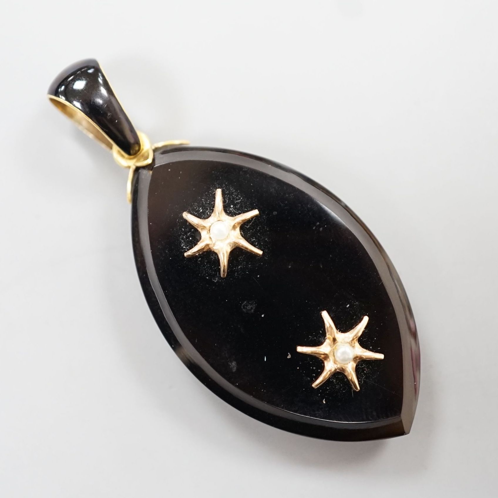 A Victorian yellow metal, black enamel, black onyx and seed pearl set mourning pendant, 57mm.