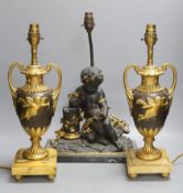 A pair of ornate guilt vase style lamps on marbled base, together with a seated cherub table lamp,
