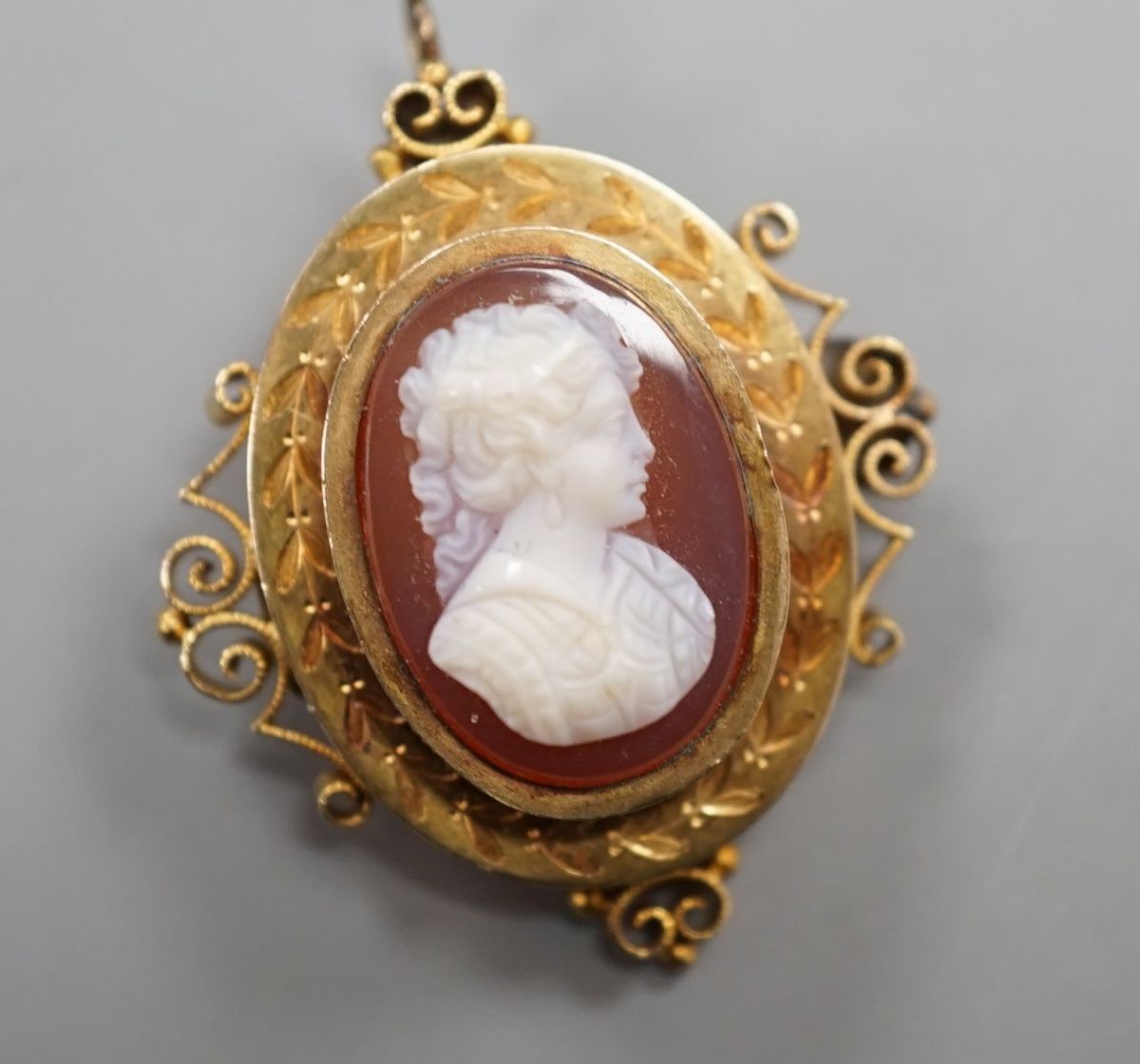 A Victorian style yellow metal and hardstone cameo set oval hardstone pendant brooch, 37mm, gross