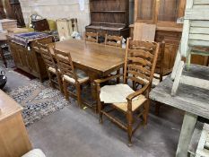An 18th century style oak dining suite comprising extending draw leaf refectory table, 243cm