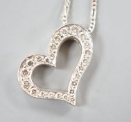 A modern 750 white metal and diamond set openwork heart pendant necklace, pendant width 22mm, chain,