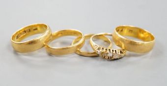 Four assorted mainly early 20th century 22ct gold wedding bands and an 18ct and diamond chip set
