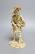 An ivory okimono figure of a man with a basket - 19cm tall