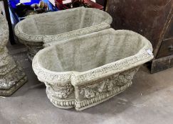 A pair of shaped oval reconstituted stone garden planters with floral swag bodies, width 82cm, depth