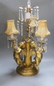 An Italian three branch gilt composition cherubic lamp with cut glass lustre drops - 64cm high