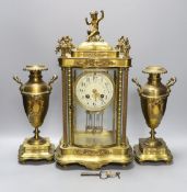 A late 19th century French brass and enamel glass mantel clock garniture with key and pendulum, 41cm