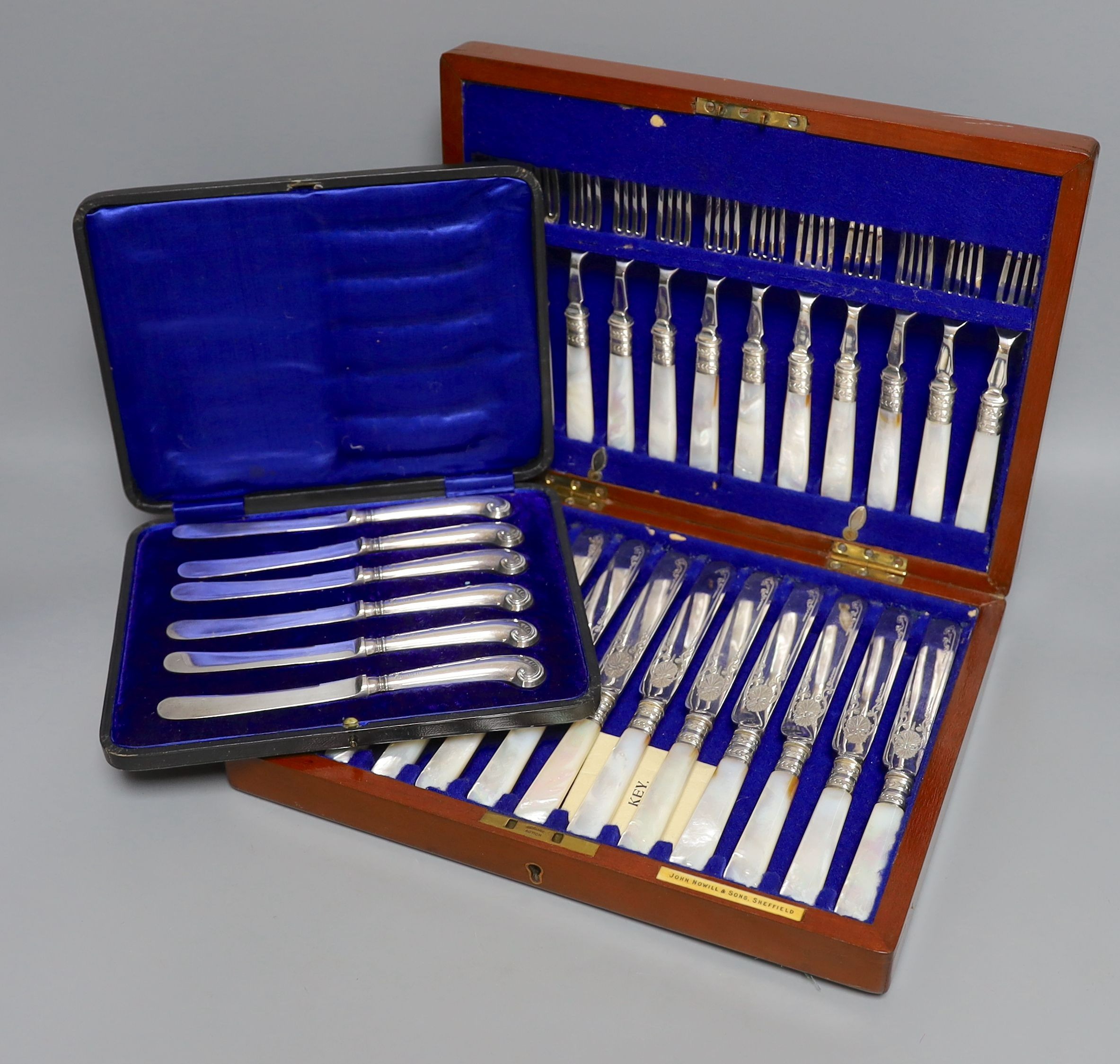 A cased set of silver handled pistol knives and a cased set of mother-of-pearl knives and forks