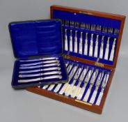 A cased set of silver handled pistol knives and a cased set of mother-of-pearl knives and forks