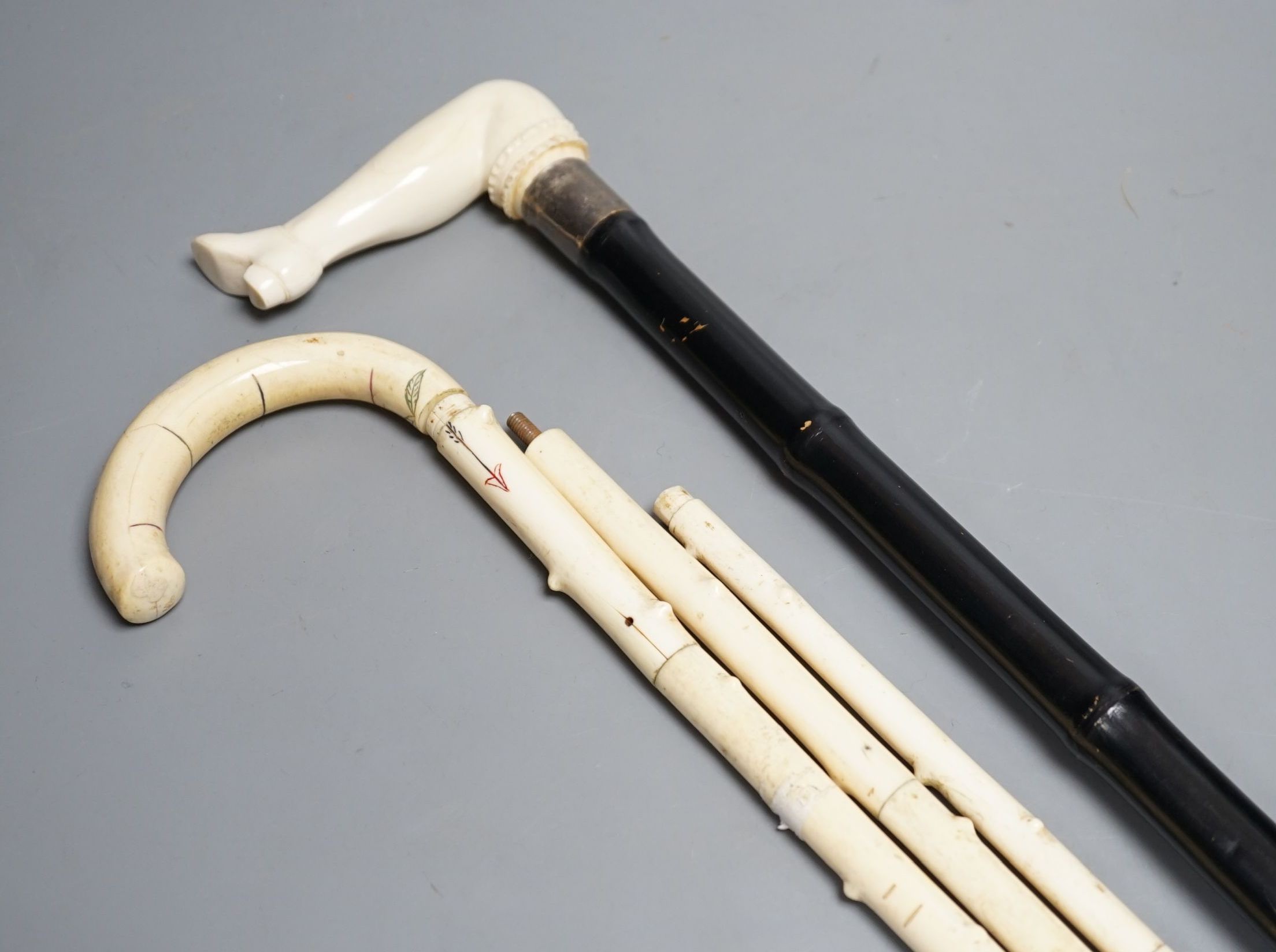 A silver mounted ivory handled ‘leg and shoe’ walking cane (88cm) and a sectional ivory walking