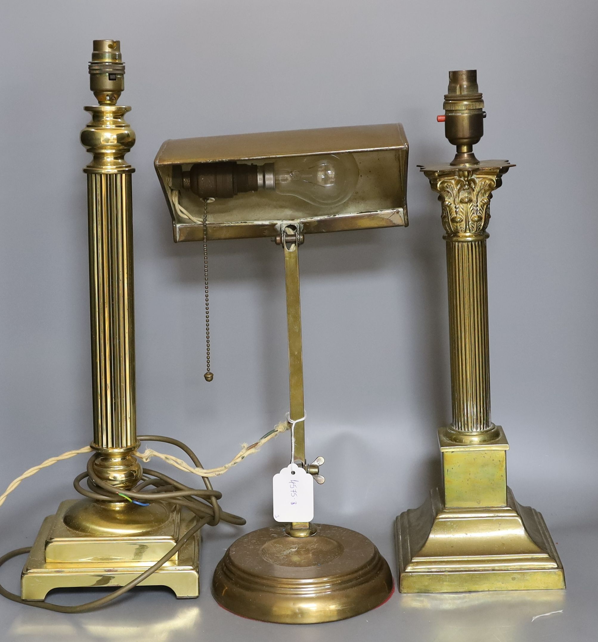 An Edwardian banker's lamp and two Corinthian column lamps - tallest 49cm