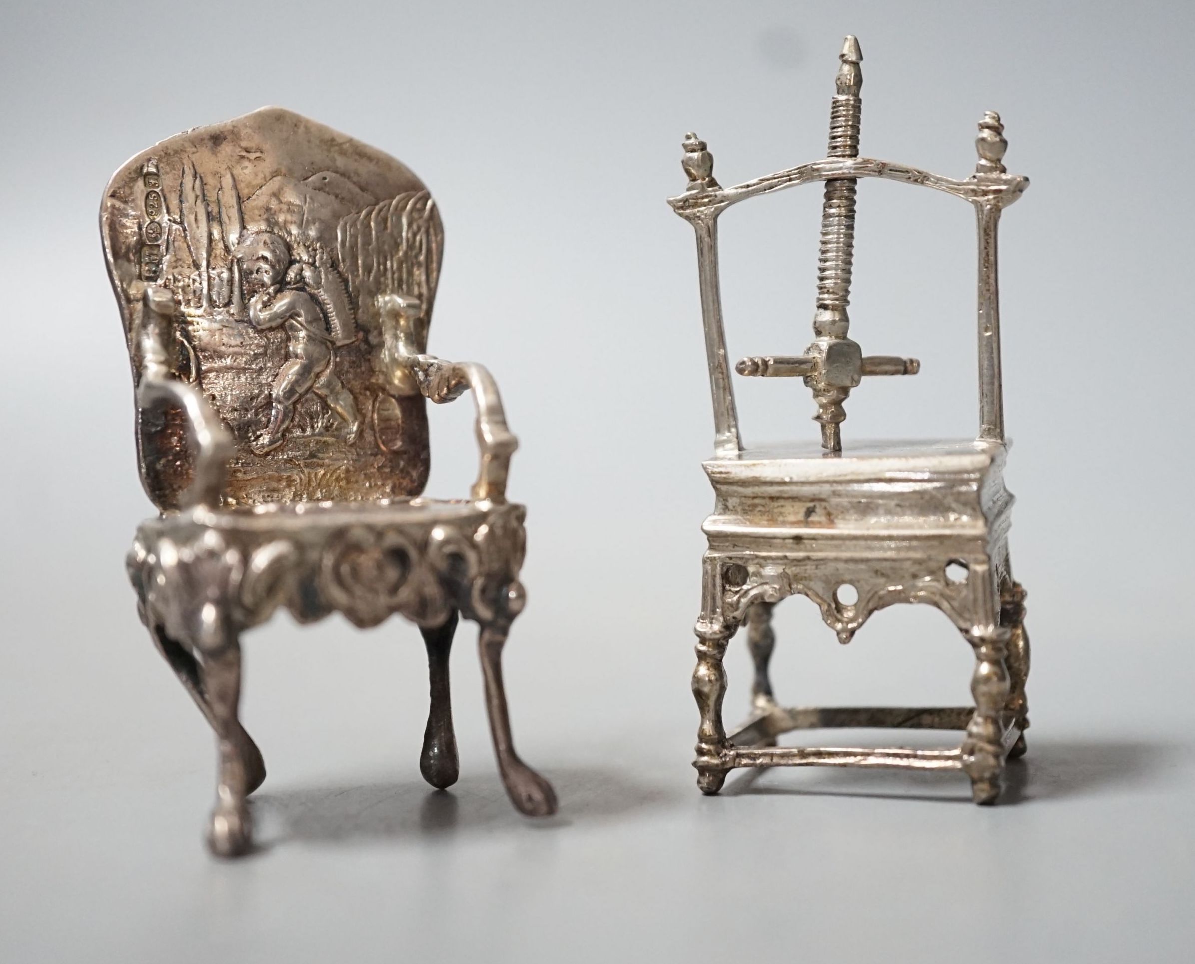 An Edwardian silver miniature model of an armchair, import marks for Glasgow, 1902, 64mm and a white