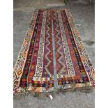 A Kilim polychrome flatweave carpet, cut centrally to create a pair of runners, each 440 x 97cm