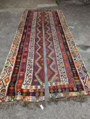 A Kilim polychrome flatweave carpet, cut centrally to create a pair of runners, each 440 x 97cm