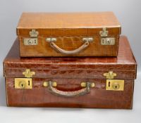 Two early 20th century crocodile hide suitcases,largest 48cms wide x 33 cms deep x 19cms high.