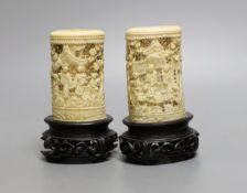 A pair of 19th century Chinese carved ivory brushpots on wooden stands - 12cm tall (including