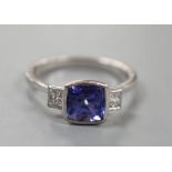 A modern 18ct white gold, single stone tanzanite and two stone diamond set ring, size R, gross