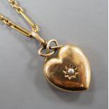 An Edwardian yellow metal and seed pearl set heart shaped locket, with glazed panel back, overall