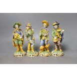 A set of four 19th century faience figures of street peddlers or performers - 18cm tall