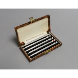 A cased set of four engine turned sterling and enamel bridge pencils, 9cm.