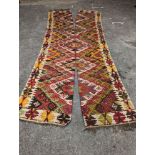 A Kelim polychrome flatweave carpet, cut centrally to create a pair of runners, each 410 x 85cm