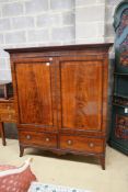 A 19th century mahogany linen press of small proportions, with panelled flamed mahogany doors