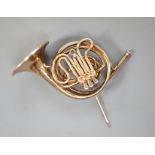 A modern silver gilt brooch, modelled as a French horn, maker, JC, London, 1981, 30mm.