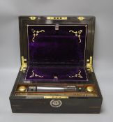 A 19th century coromandel wood writing slope with mother-of-pearl cartouche and original purple