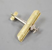 An early 20th century 15ct, white metal and three stone diamond set bi-plane brooch, with
