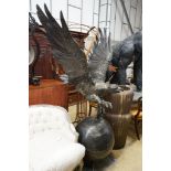 A large cast metal faux bronze eagle, salmon and orb garden ornament, height 200cm