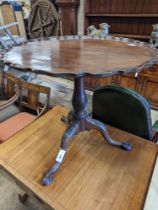 A George III style circular mahogany tripod table, with piecrust top and claw and ball feet,